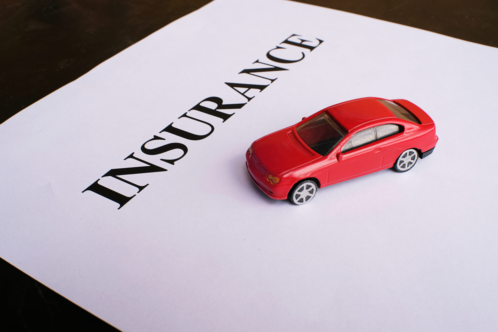 insurance form with miniature car